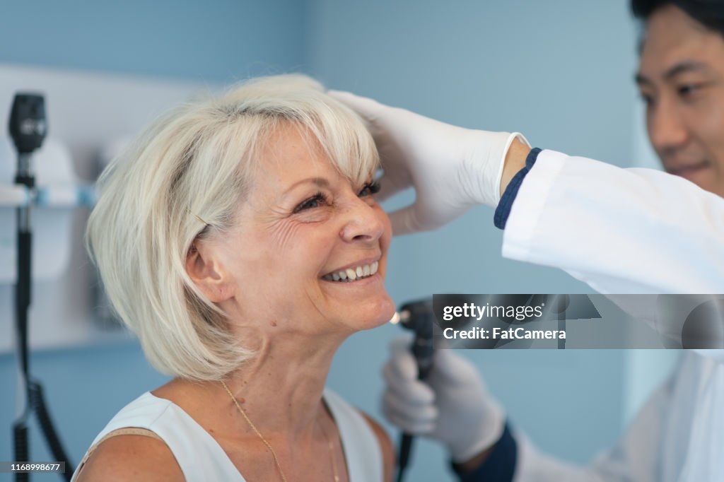 Mogen vuxen kvinna i medicinsk konsultation med manlig läkare