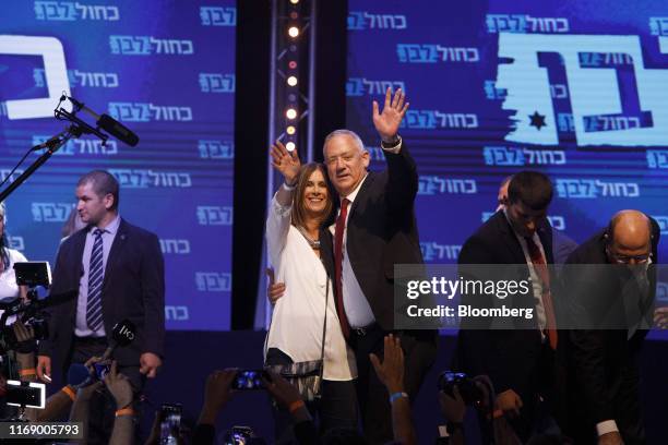 Benny Gantz, leader of the Blue and White party, right, and his wife, Revital Gantz, wave to supporters as they stand on stage in Tel Aviv, Israel,...