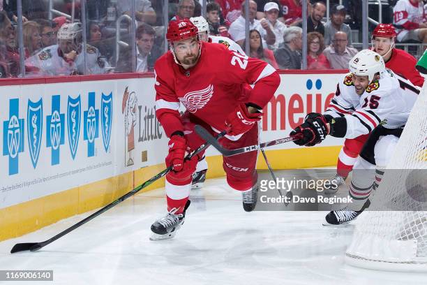 Dylan McIlrath of the Detroit Red Wings skates with the puck behind the net followed by Zack Smith of the Chicago Blackhawks during a pre-season NHL...