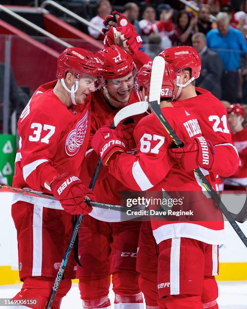 Michael Rasmussen of the Detroit Red Wings celebrates a goal with teammates against the Chicago Blackhawks during a pre-season NHL game at Little...