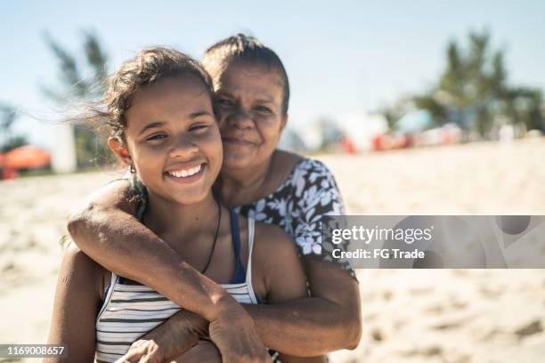 portret van grootmoeder en kleindochter omhelzen in het strand - pardo brazilian stockfoto's en -beelden