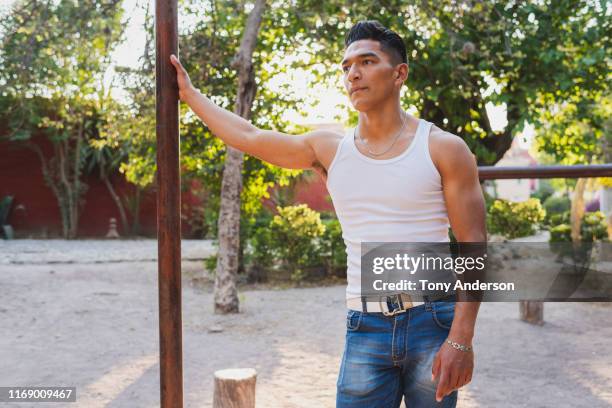 young man at outdoor gym in public park - man in tank top stock pictures, royalty-free photos & images