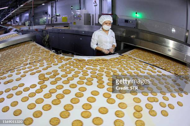 This photo taken on September 17, 2019 shows a worker monitoring a biscuit production line in Huaibei in China's eastern Anhui province. / China OUT