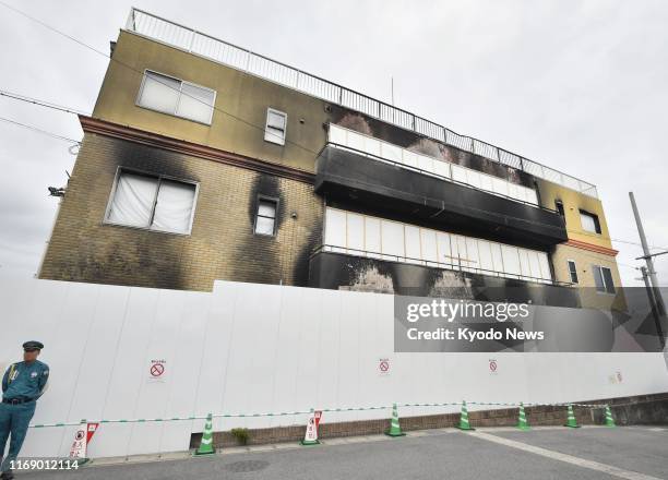 Security guard stands in front of a studio of Kyoto Animation Co. In Kyoto on Sept. 18 two months after it was hit by an arson attack that killed 35...