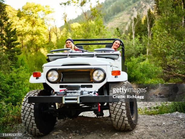young couple driving an off road 4x4 - off road vehicle stock pictures, royalty-free photos & images