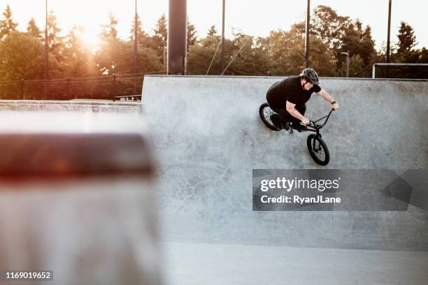 adult woman bmx bike rider im ramp park - half pipe stock-fotos und bilder