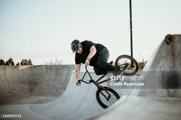 adult woman bmx bike rider at ramp park - bmx freestyle stock pictures, royalty-free photos & images