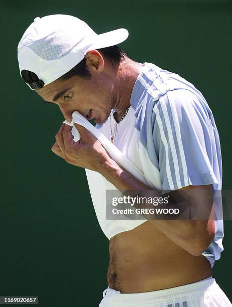 Nicolas Lapentti of Ecuador wipes his face with his shirt during his loss to Sebastien Grosjean of France in their third round men's singles match at...