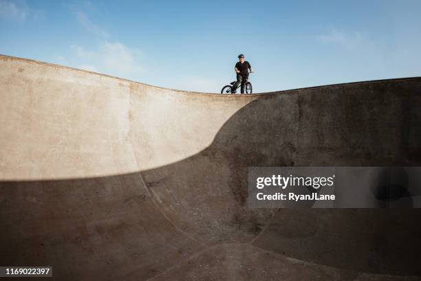 adult woman bmx bike rider at ramp park - halfpipe imagens e fotografias de stock