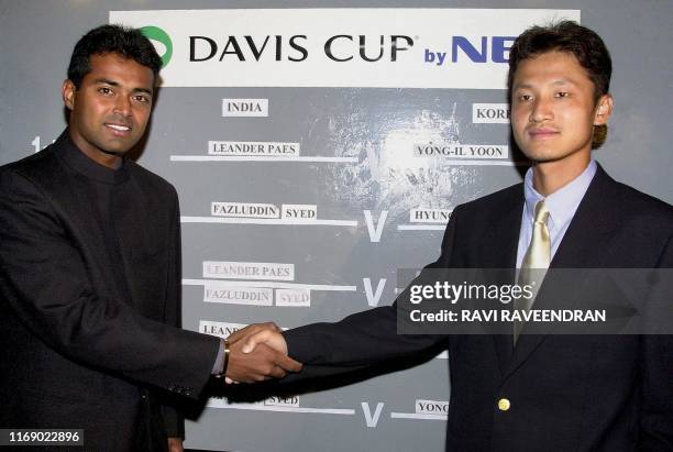 Number one Indian tennis player Leander Paes shakes hands with South Korean player Yong-II-Yoon 06 April 2000 in New Delhi after the draw of lots for...