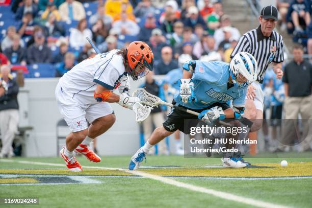 Full-length shot of a Johns Hopkins University Men's Lacrosse player, vying with an opponent for the ball during a National Collegiate Athletic...