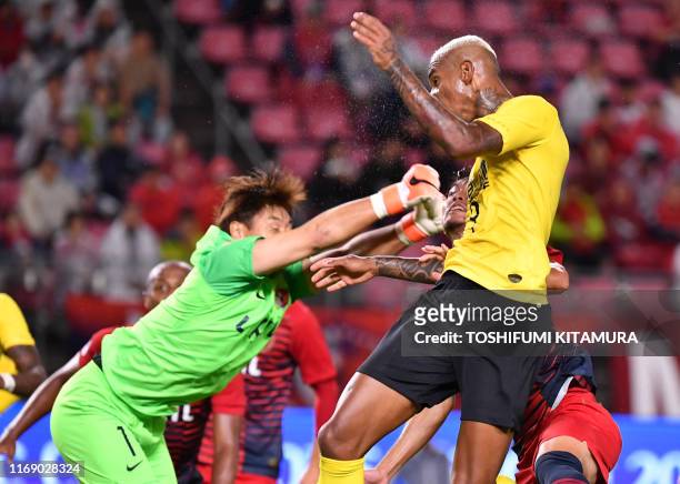 Guangzhou's midfielder Anderson Talisca heads to score a goal in front of Kashima's goalkeeper Kuwon Sun-Tae during the AFC Champions League...
