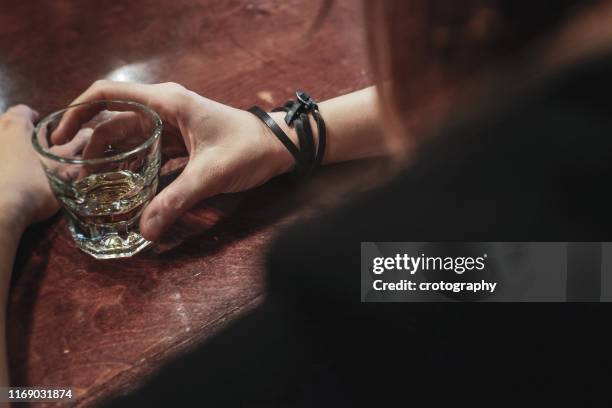 woman drinking a shot of whisky in a bar - alcohol abuse 個照片及圖片檔