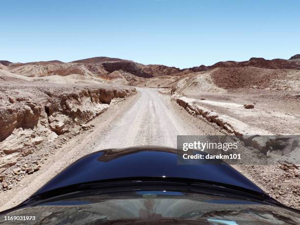 car driving along a desert road, death valley national park, nevada, united states - landskap stockfoto's en -beelden