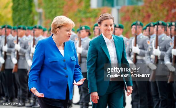 German Chancellor Angela Merkel and Serbian Prime Minister Ana Brnabic inspect a military honor guard during a welcoming ceremony in front of the...