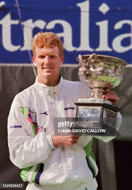 American tennis player Jim Courier holds up the Winner's trophy after defeating Sweden's Stefan Edberg here 26 january 1992 in Melbourne during the...