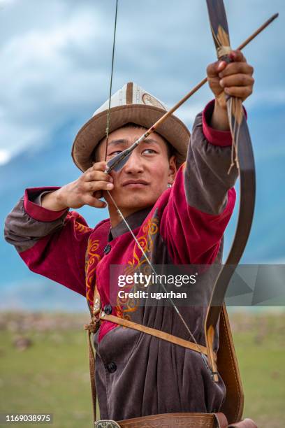 traditional kyrgyz hunter holding traditional arrow. - kazakhstan man stock pictures, royalty-free photos & images