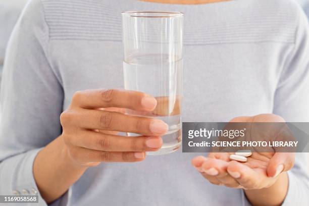 woman holding tablets and water - ibuprofen 個照片及圖片檔