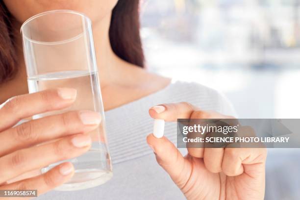 woman holding tablet and water - ibuprofen 個照片及圖片檔