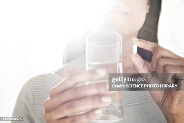 woman holding tablet and water - ibuprofen 個照片及圖片檔