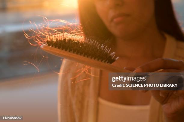 worried woman holding hairbrush with hair - hairbrush 個照片及圖片檔