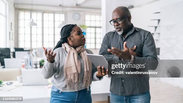 senior african businessman having problems at work with his assistant - conflict office stock pictures, royalty-free photos & images