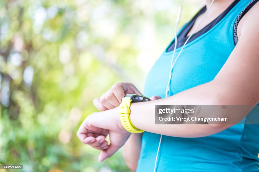 Fitness woman checks results after workout session on smartwatch on fitness application.