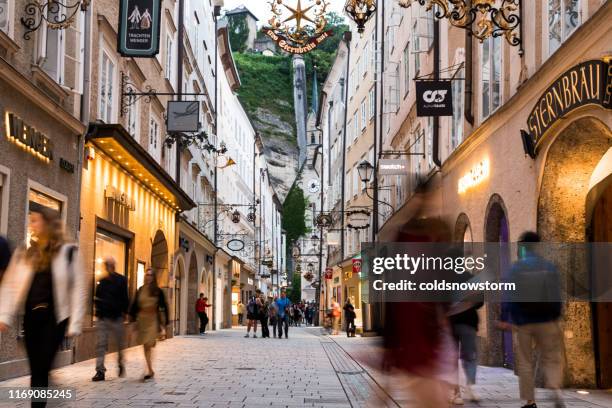 tiendas de lujo y calles del casco antiguo iluminadas por la noche en salzburgo, austria - salzburgo fotografías e imágenes de stock