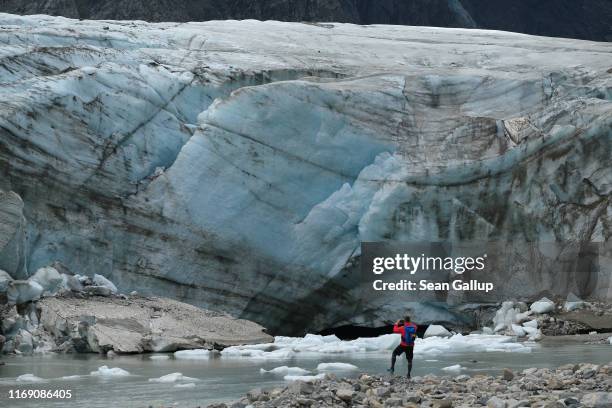 Visitor snaps a photo of a wall of ice of the Pasterze glacier on August 13, 2019 near Heiligenblut am Grossglockner, Austria. The Pasterze,...