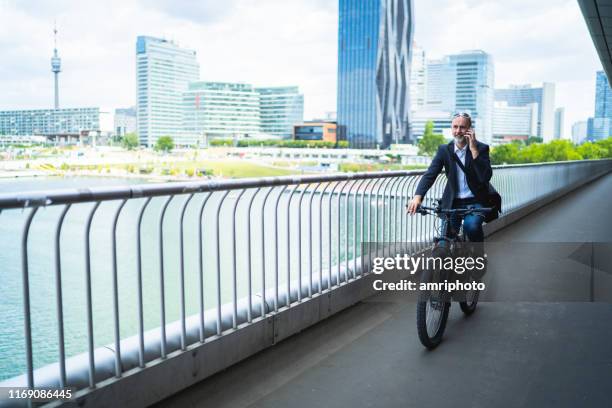 umweltfreundliche art zu arbeiten, pendler auf dem fahrrad im büroviertel - danube river stock-fotos und bilder