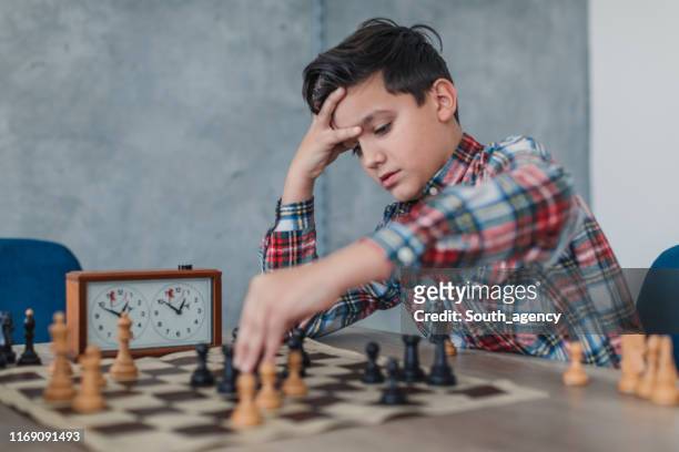 smart boy playing chess alone - chess timer stock pictures, royalty-free photos & images