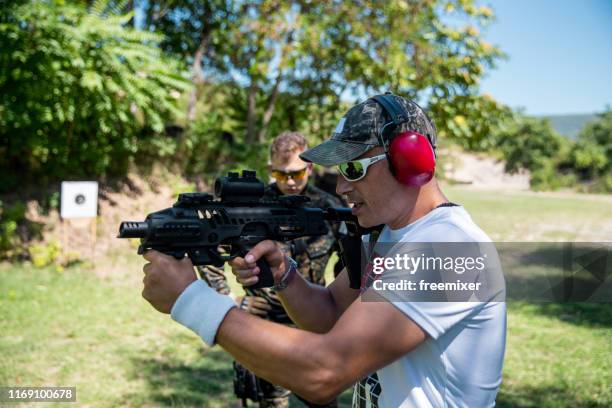 instructor practice gun shooting on shooting range - semi automatic pistol stock pictures, royalty-free photos & images