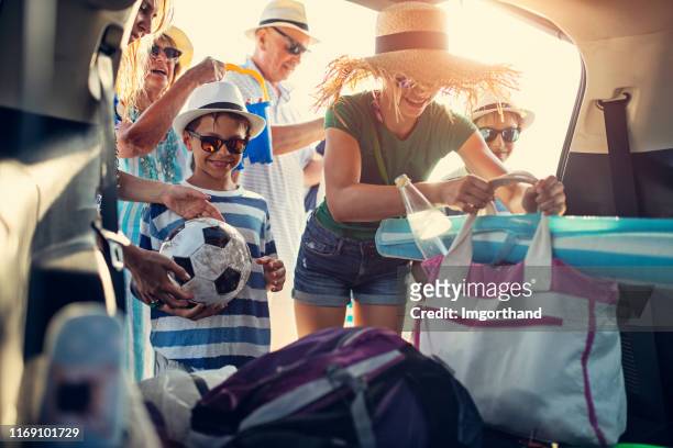 multi generation familie is packing auto. - holiday packing stockfoto's en -beelden