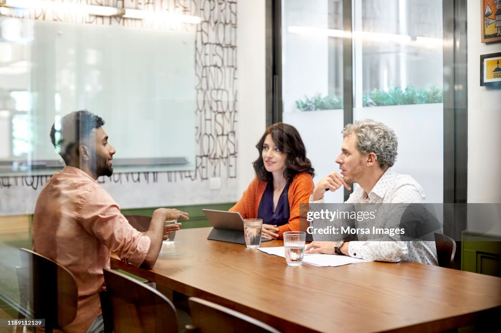 Colleagues discussing in meeting at office