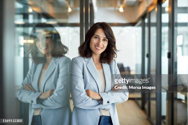 portrait of confident businesswoman in office - informeel zakelijk stockfoto's en -beelden