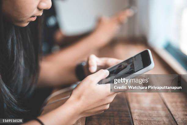 boy and girl teens holding smartphone in coffee shop. - social media followers stock pictures, royalty-free photos & images