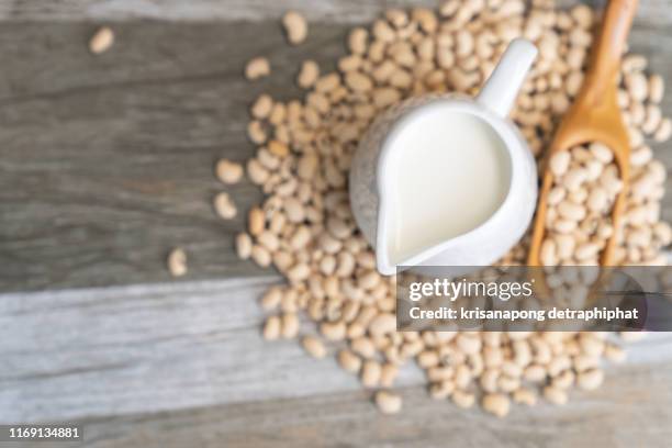 soy milk and soy bean on wooden background - sojamilch stock-fotos und bilder