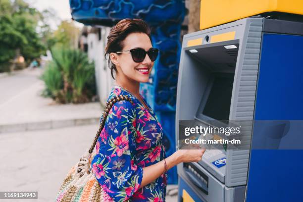 tourist using credit card on the atm - tunic woman stock pictures, royalty-free photos & images