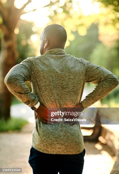 lower back pain is common amongst runners - lower back stock pictures, royalty-free photos & images