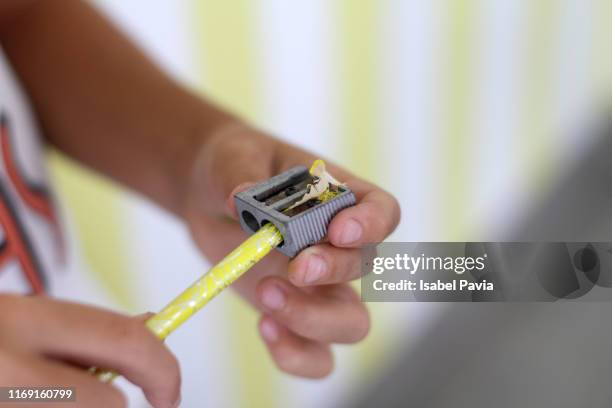 detail of boy sharpening a pencil - pencil sharpener stock pictures, royalty-free photos & images
