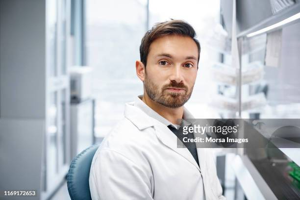 confident male doctor at research center - handsome doctors stock-fotos und bilder