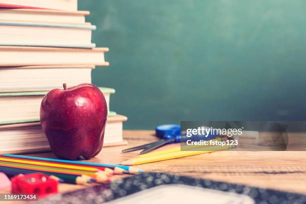 group of school supplies on wooden desk with chalkboard. - september background stock pictures, royalty-free photos & images