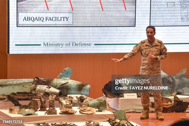 Saudi defence ministry spokesman Colonel Turki bin Saleh al-Malki displays pieces of what he said were Iranian cruise missiles and drones recovered...