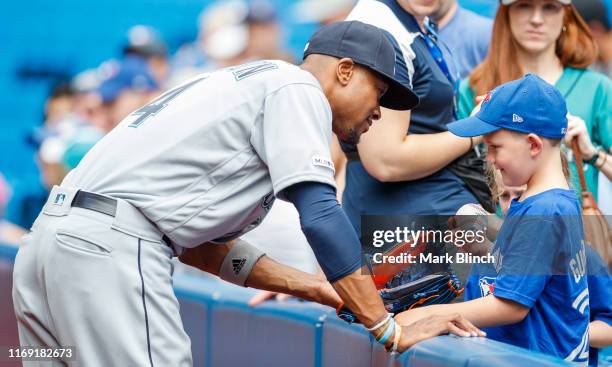 Keon Broxton of the Seattle Mariners greets a young fan before playing the Toronto Blue Jays in their MLB game at the Rogers Centre on August 18,...