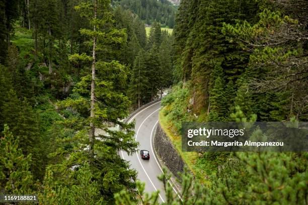 car in curved road passing through the mountains - wonderlust stock-fotos und bilder