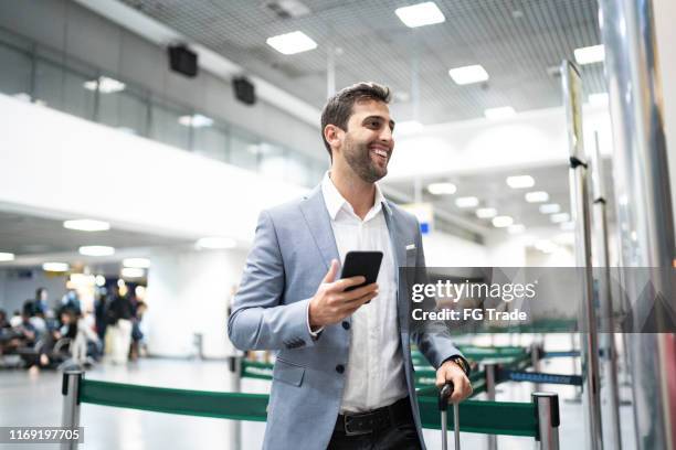 businessman boarding using mobile on airport - heathrow stock pictures, royalty-free photos & images