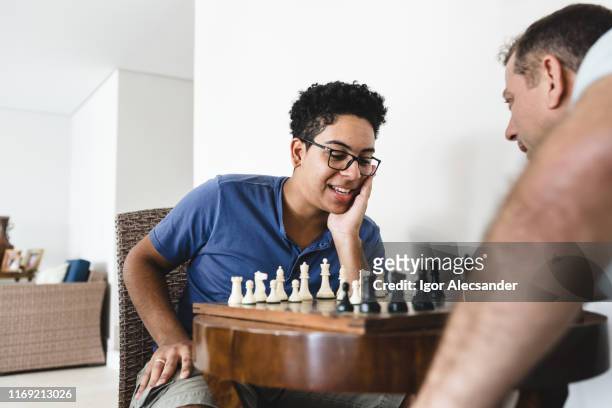 garçon de l'adolescence jouant des échecs - father son challenge round two photos et images de collection
