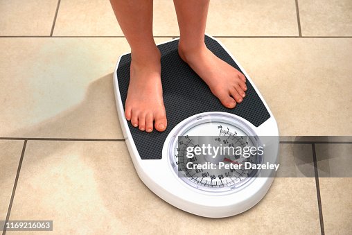 Young Obese Boy on Bathroom Scales Young Obese Boy on Bathroom Scales