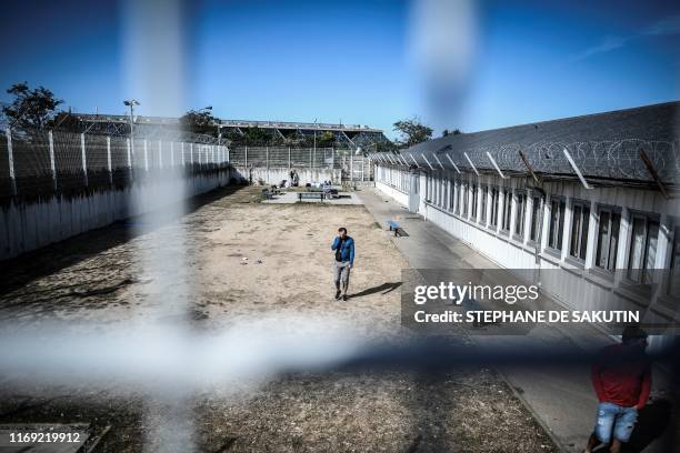 Men walk in a courtyard at the 'Centre de Retention Administrative' , a migrant detention centre in Vincennes, eastern Paris, on September 18, 2019.
