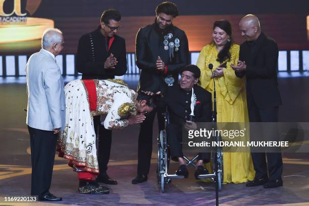 Bollywood actor Ranveer Singh bows after actor Jagdeep received the Lifetime Achievement award during the 20th International Indian Film Academy...